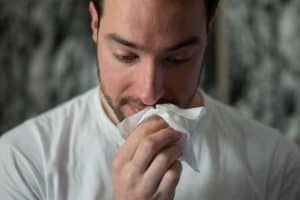Person wiping their nose with a tissue